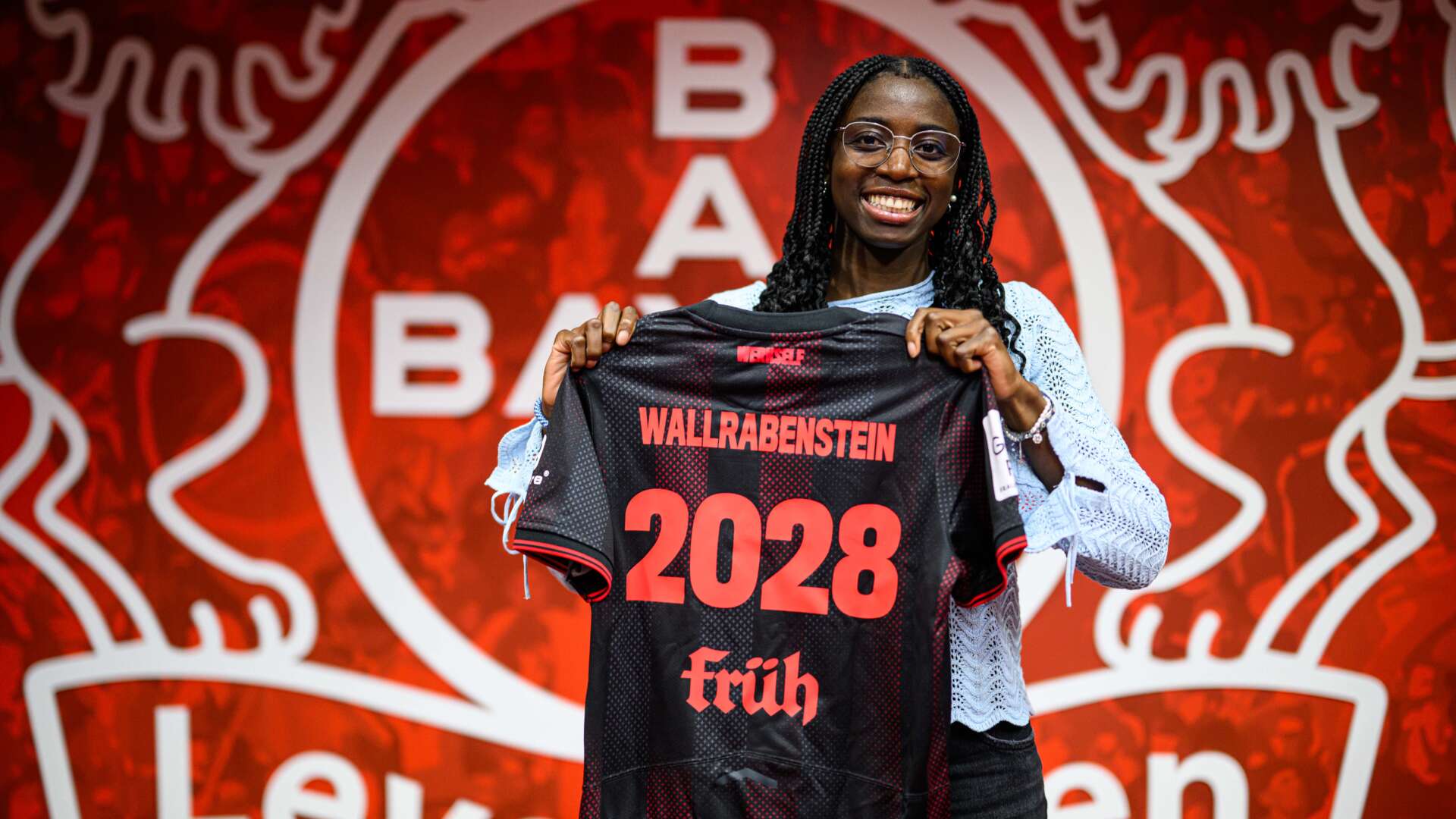 Emily Wallrabenstein hält das Bayer 04-Trikot in der Hand