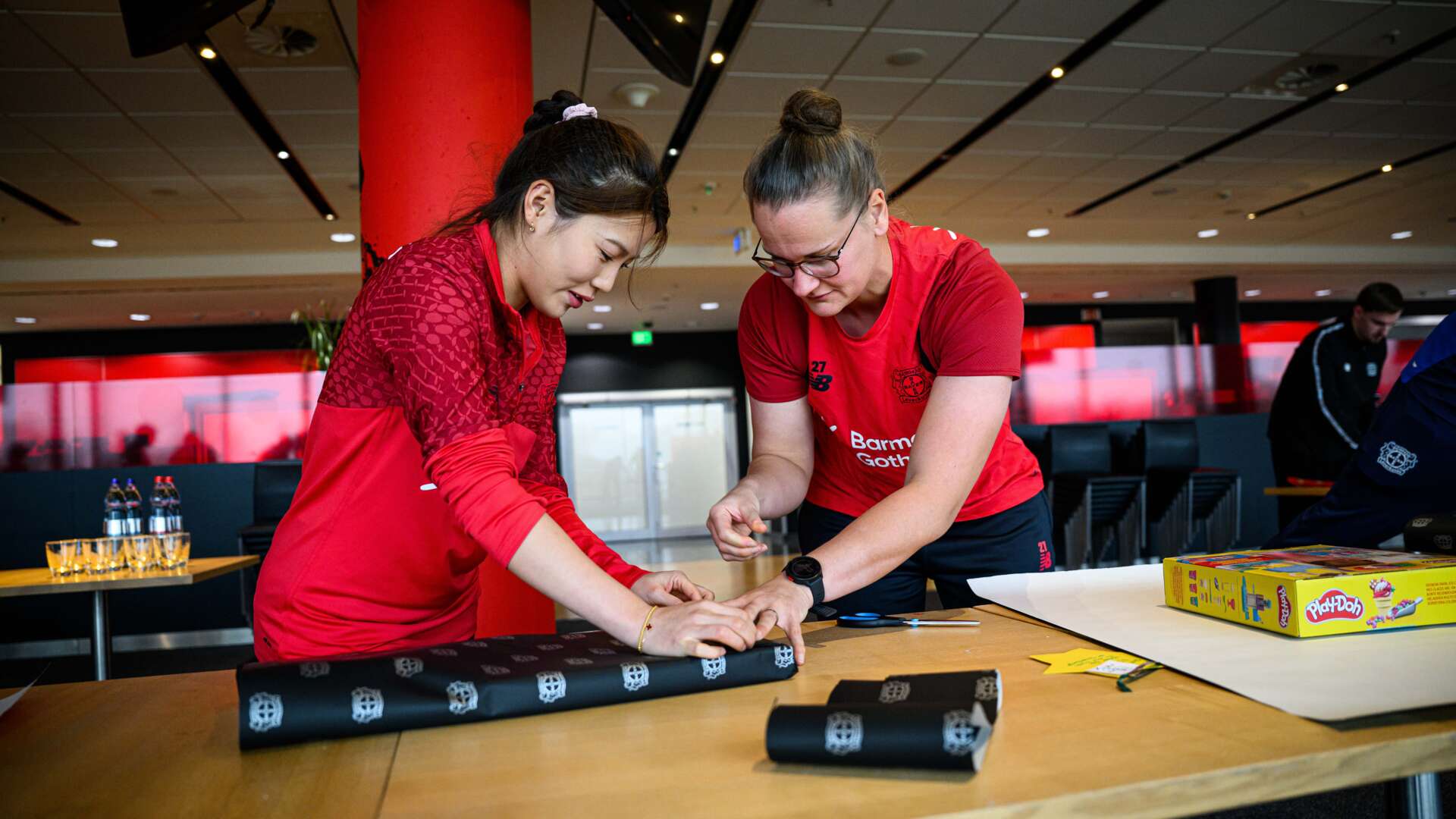 Shen Menglu und Friederike Repohl verpacken Geschenke