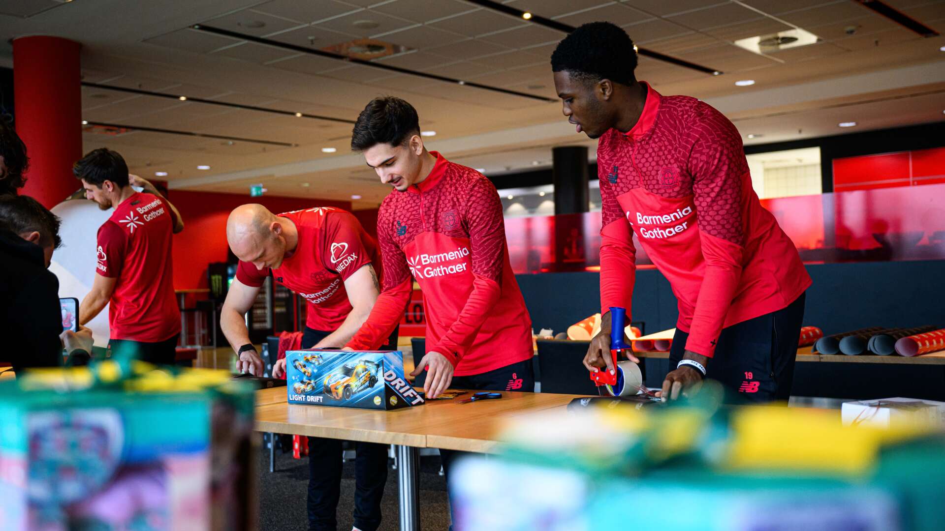 Jonas Hofmann, Niklas Lomb, Francesco Buono und Isaiah Eichie verpacken Geschenke