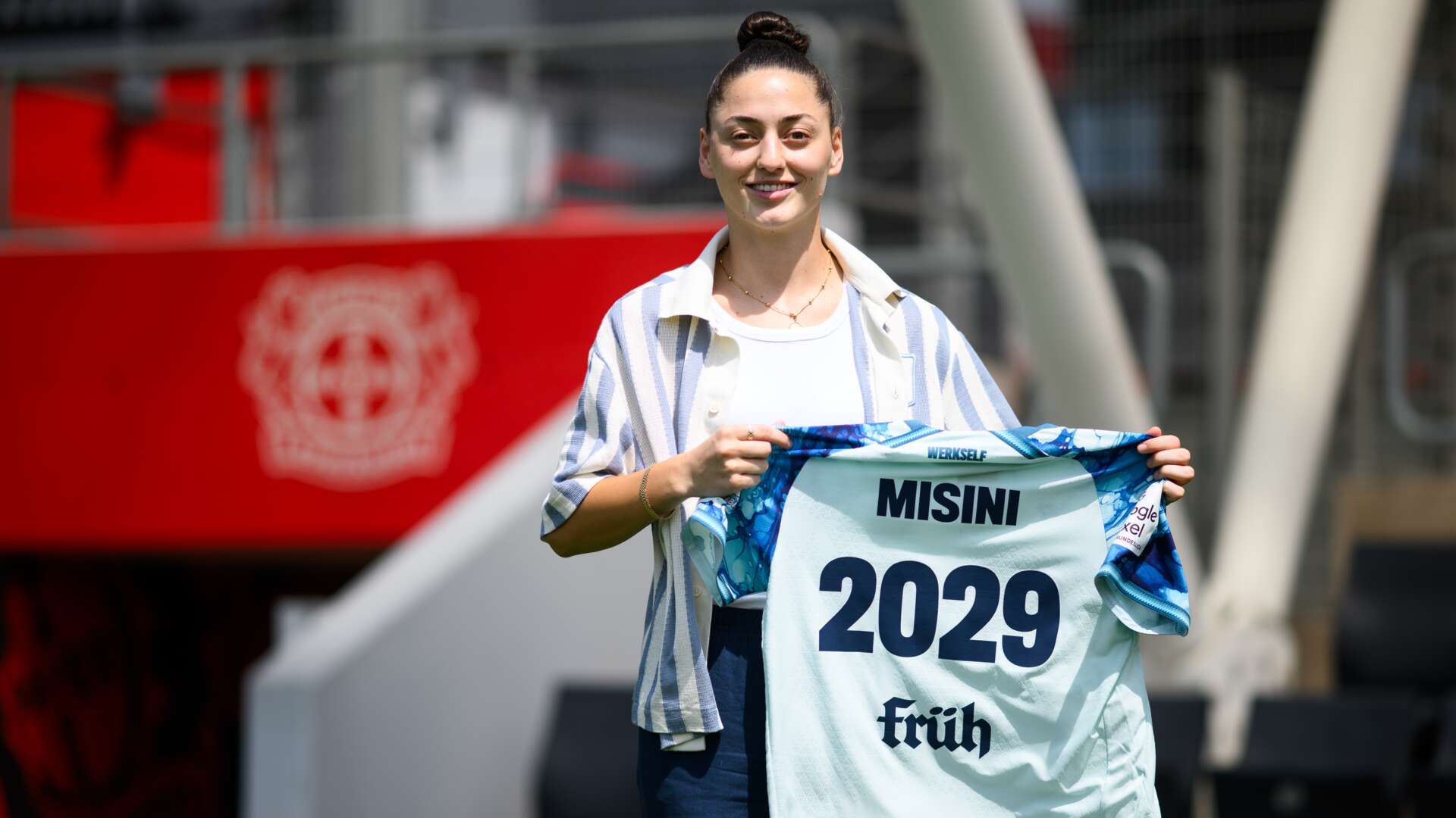 Lumbardha Misini holding a Bayer 04 shirt marked MISINI and 2029 at her signing